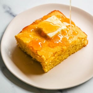 This moist and fluffy hot honey cornbread is sweet, slightly spicy, and absolutely packed with flavor from the very first bite! This is the most irresistible cornbread topped with hot honey butter you will ever make, and it comes together in just one bowl in under 30 minutes, making it the easiest and most flavorful side dish.