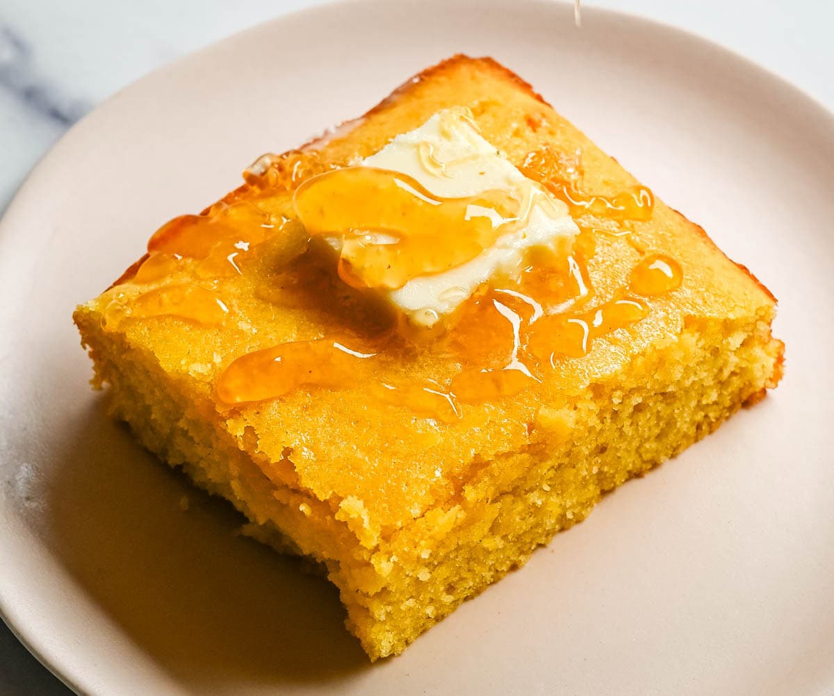 This moist and fluffy hot honey cornbread is sweet, slightly spicy, and absolutely packed with flavor from the very first bite! This is the most irresistible cornbread topped with hot honey butter you will ever make, and it comes together in just one bowl in under 30 minutes, making it the easiest and most flavorful side dish.