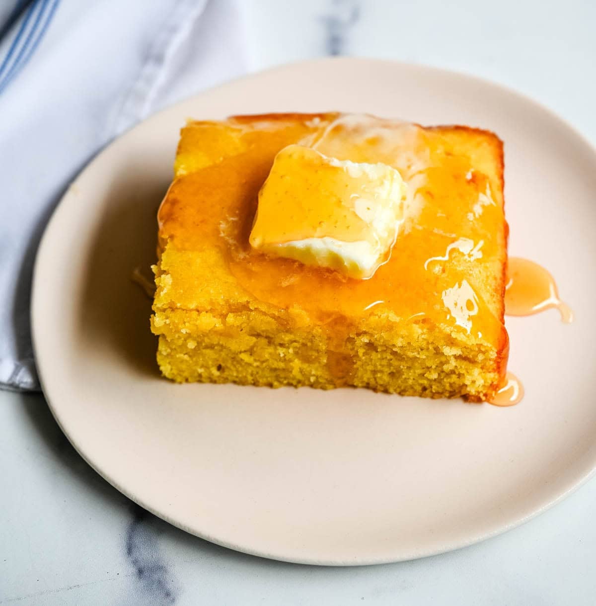 This moist and fluffy hot honey cornbread is sweet, slightly spicy, and absolutely packed with flavor from the very first bite! This is the most irresistible cornbread topped with hot honey butter you will ever make, and it comes together in just one bowl in under 30 minutes, making it the easiest and most flavorful side dish.