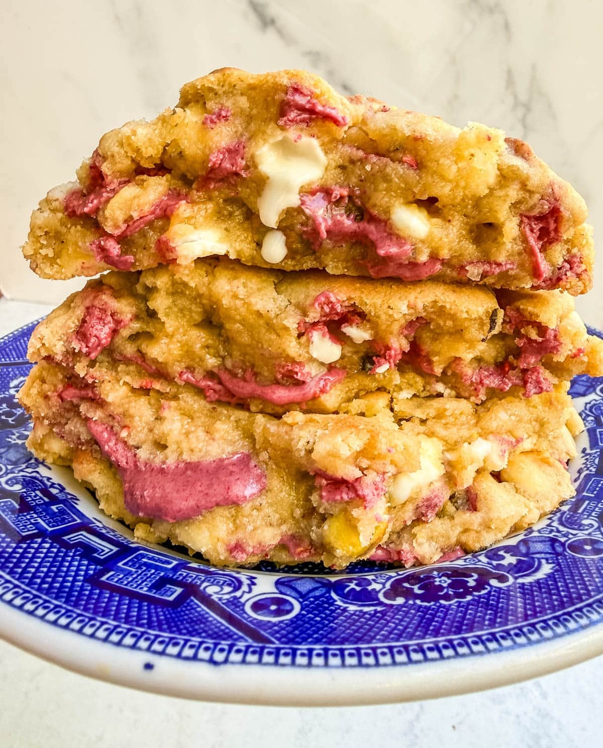 These Levain Bakery Raspberry Pistachio cookies are a homemade copycat of Levain Bakery's new summer flavor, which combines raspberry chips, crunchy pistachios, and creamy white chocolate chips in their signature thick, bakery-style cookie. Our version uses a homemade raspberry chip made from crushed freeze-dried raspberries and white chocolate for that same fruity flavor without needing specialty baking chips. These cookies are thick, gooey, and loaded with tart raspberry, rich white chocolate, and crunchy salted pistachios in every bite!