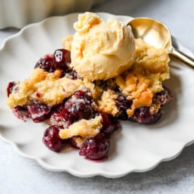 Want to make cherry cobbler with fresh cherries? This recipe combines a jammy cherry filling with a golden sugar cookie topping for the perfect summer dessert.