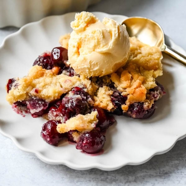 Want to make cherry cobbler with fresh cherries? This recipe combines a jammy cherry filling with a golden sugar cookie topping for the perfect summer dessert.