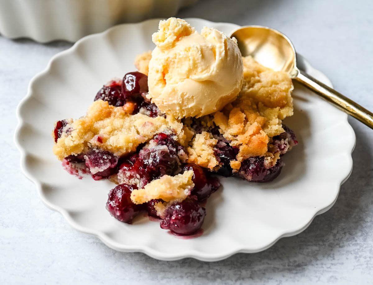 Want to make cherry cobbler with fresh cherries? This recipe combines a jammy cherry filling with a golden sugar cookie topping for the perfect summer dessert.