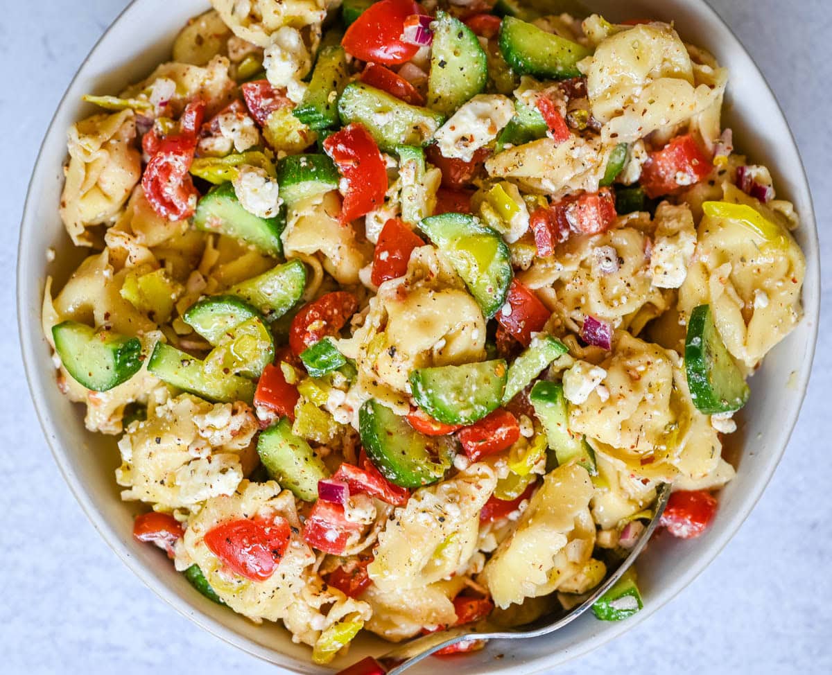 Greek Cheese Tortellini Pasta Salad with fresh tomatoes, cucumbers, red onion, feta cheese, tossed in a tangy homemade Greek dressing. This is such an easy tortellini pasta salad recipe and everyone loves it!