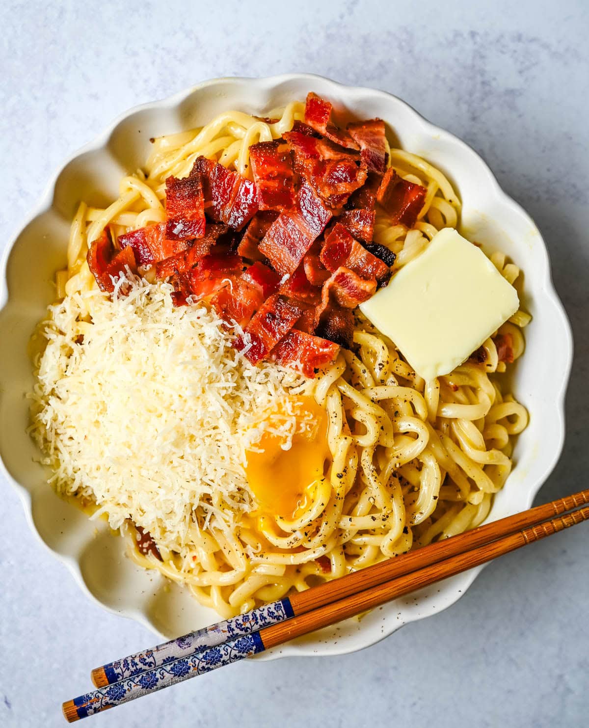 This Carbonara Udon recipe is creamy, cheesy, and ridiculously easy. This viral Japan noodle dish is a quick and easy 20-minute weeknight dinner. Thick udon noodles, silky egg yolk and parmesan cheese sauce, crispy bacon, and tons of black pepper. It's the viral Tokyo dish everyone's been lining up for, except you can make it at home in no time at all.