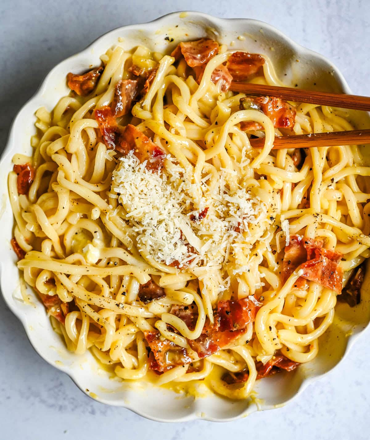 This Carbonara Udon recipe is creamy, cheesy, and ridiculously easy. This viral Japan noodle dish is a quick and easy 20-minute weeknight dinner. Thick udon noodles, silky egg yolk and parmesan cheese sauce, crispy bacon, and tons of black pepper. It's the viral Tokyo dish everyone's been lining up for, except you can make it at home in no time at all.