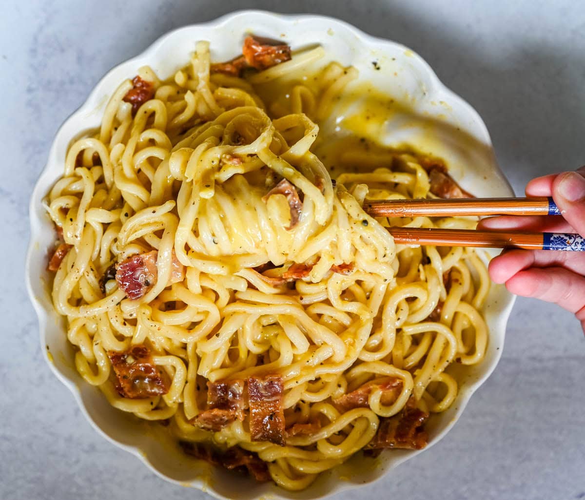 This Carbonara Udon recipe is creamy, cheesy, and ridiculously easy. This viral Japan noodle dish is a quick and easy 20-minute weeknight dinner. Thick udon noodles, silky egg yolk and parmesan cheese sauce, crispy bacon, and tons of black pepper. It's the viral Tokyo dish everyone's been lining up for, except you can make it at home in no time at all.