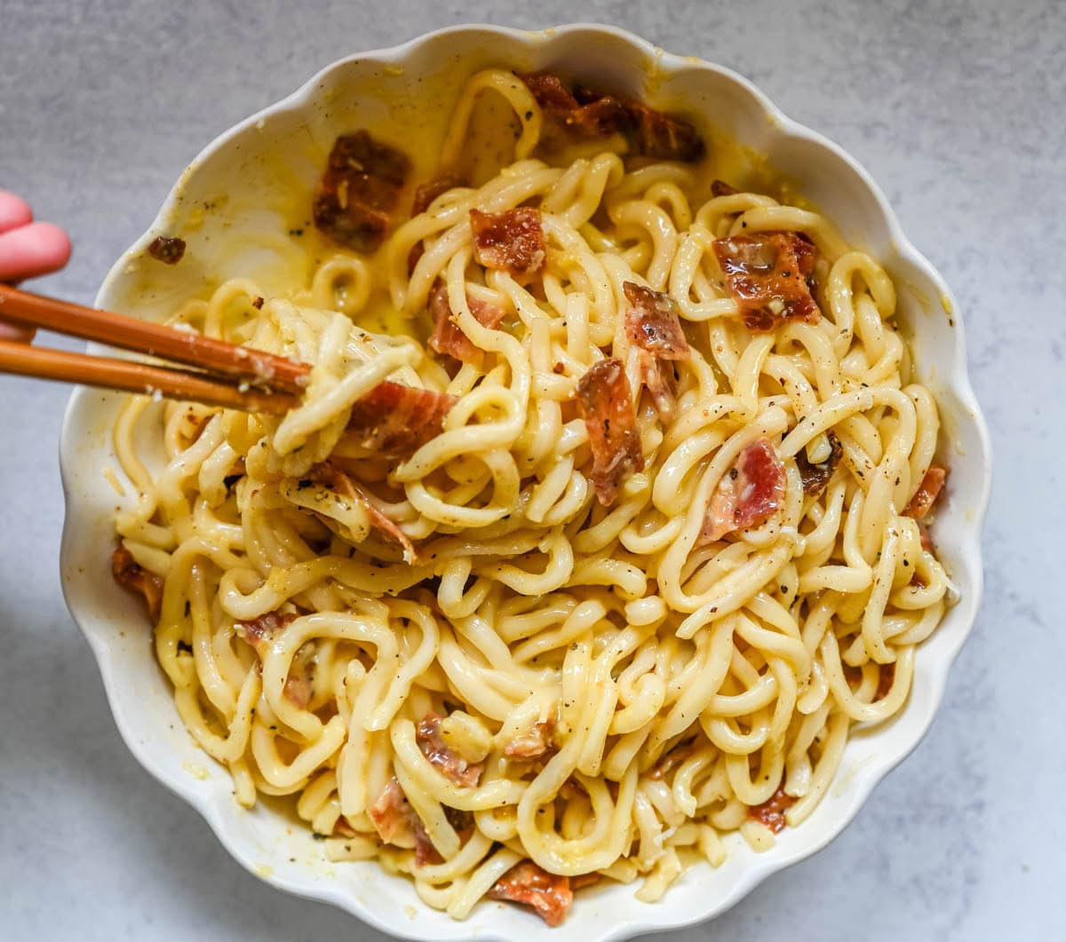 This Carbonara Udon recipe is creamy, cheesy, and ridiculously easy. This viral Japan noodle dish is a quick and easy 20-minute weeknight dinner. Thick udon noodles, silky egg yolk and parmesan cheese sauce, crispy bacon, and tons of black pepper. It's the viral Tokyo dish everyone's been lining up for, except you can make it at home in no time at all.