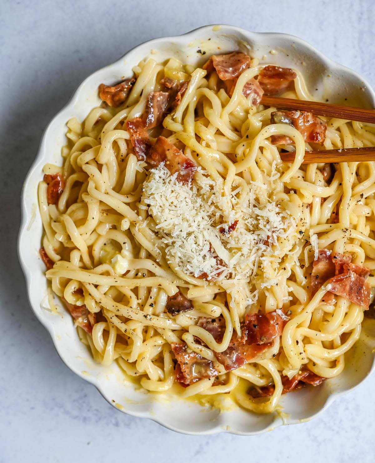 This Carbonara Udon recipe is creamy, cheesy, and ridiculously easy. This viral Japan noodle dish is a quick and easy 20-minute weeknight dinner. Thick udon noodles, silky egg yolk and parmesan cheese sauce, crispy bacon, and tons of black pepper. It's the viral Tokyo dish everyone's been lining up for, except you can make it at home in no time at all.