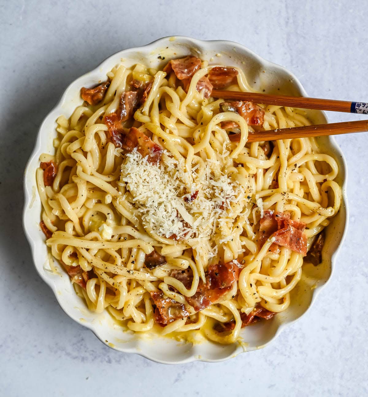 This Carbonara Udon recipe is creamy, cheesy, and ridiculously easy. This viral Japan noodle dish is a quick and easy 20-minute weeknight dinner. Thick udon noodles, silky egg yolk and parmesan cheese sauce, crispy bacon, and tons of black pepper. It's the viral Tokyo dish everyone's been lining up for, except you can make it at home in no time at all.