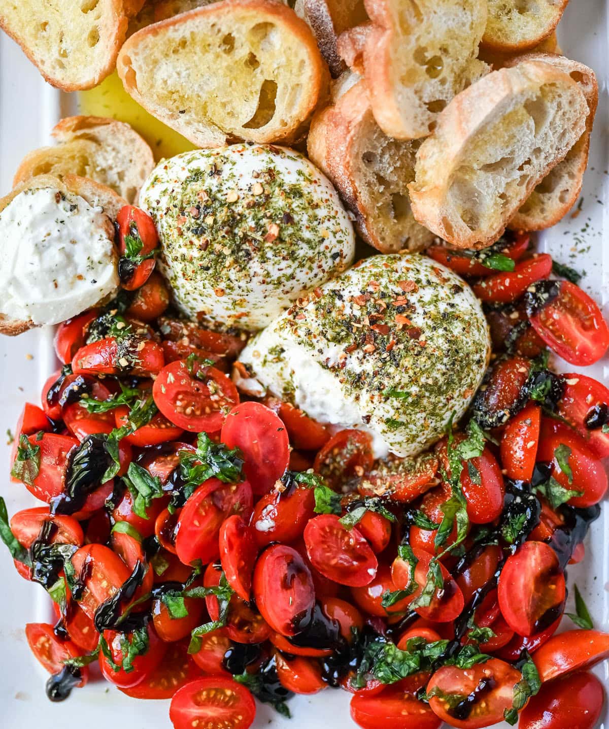 This Burrata Tomato Salad is made with creamy burrata, juicy tomatoes, fresh basil, and a balsamic drizzle — this 10-minute Burrata Caprese Salad is the easiest no-cook summer appetizer.