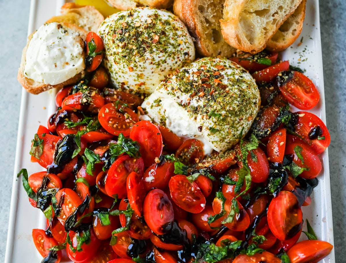 This Burrata Tomato Salad is made with creamy burrata, juicy tomatoes, fresh basil, and a balsamic drizzle — this 10-minute Burrata Caprese Salad is the easiest no-cook summer appetizer.