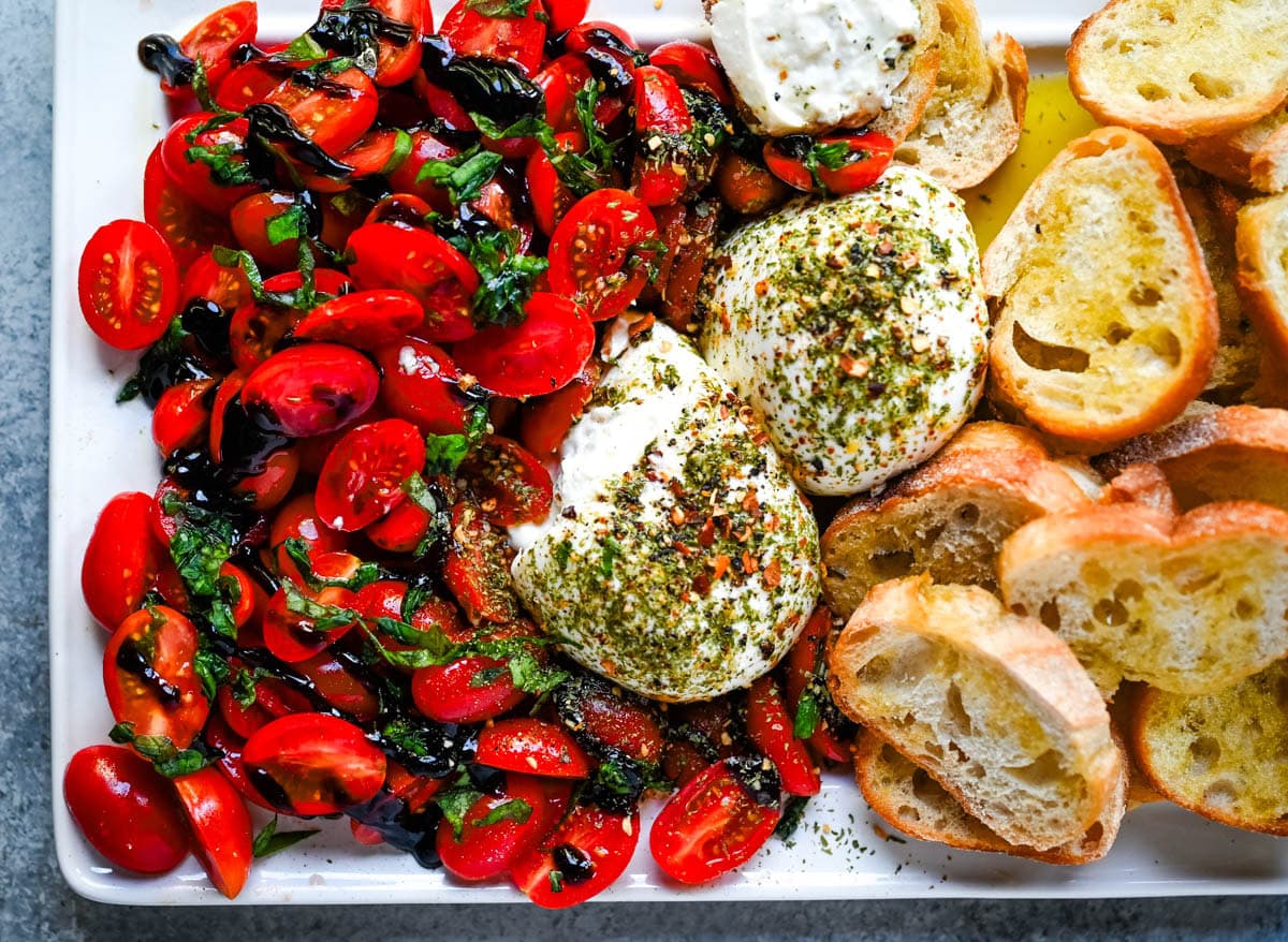 This Burrata Tomato Salad is made with creamy burrata, juicy tomatoes, fresh basil, and a balsamic drizzle — this 10-minute Burrata Caprese Salad is the easiest no-cook summer appetizer.