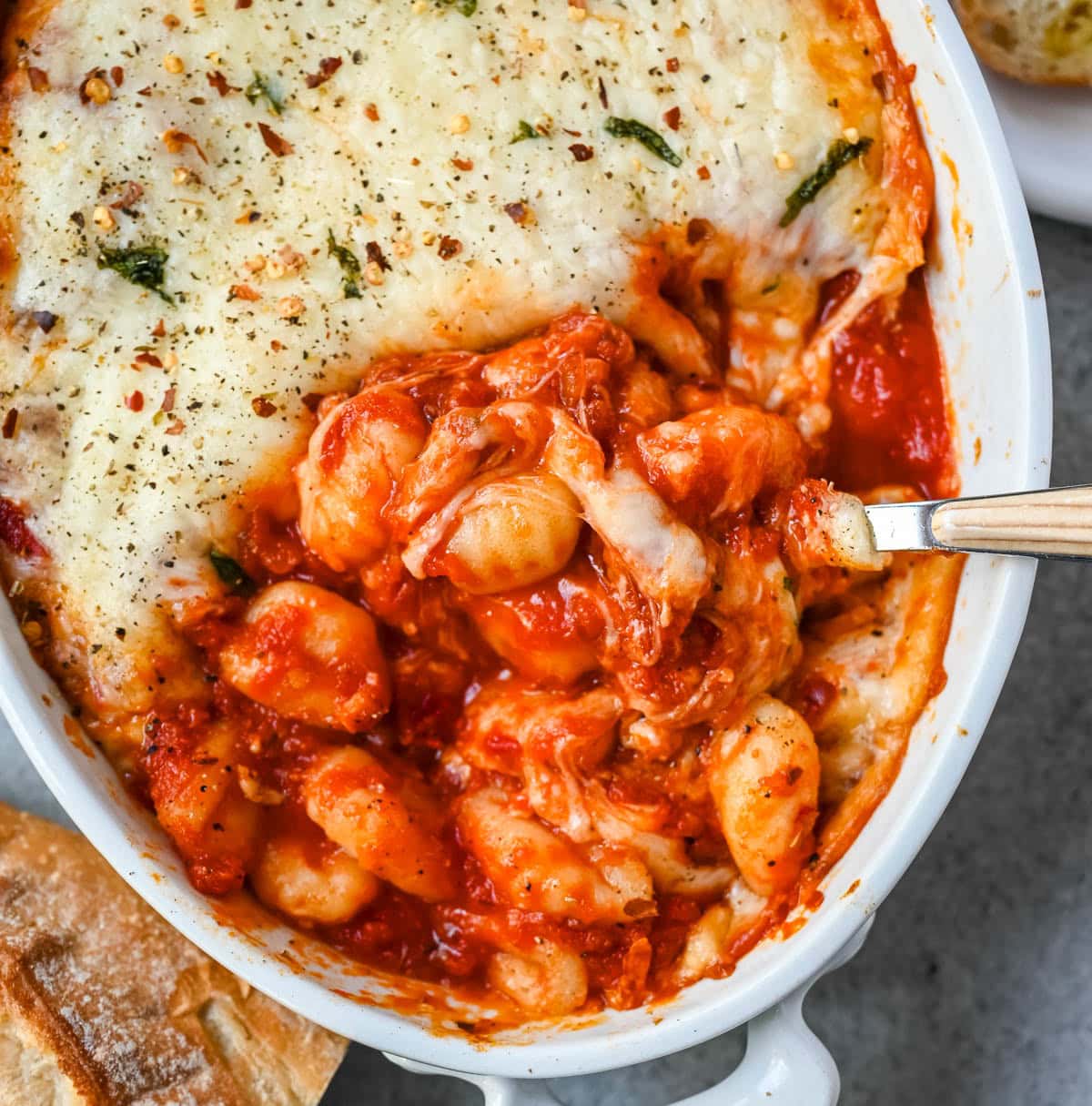 This cheesy baked gnocchi is made with pillowy gnocchi tossed in marinara sauce, layered with mozzarella and parmesan, and baked until golden and bubbly. Topped with fresh basil, this easy gnocchi bake comes together in one dish and tastes like it took hours.