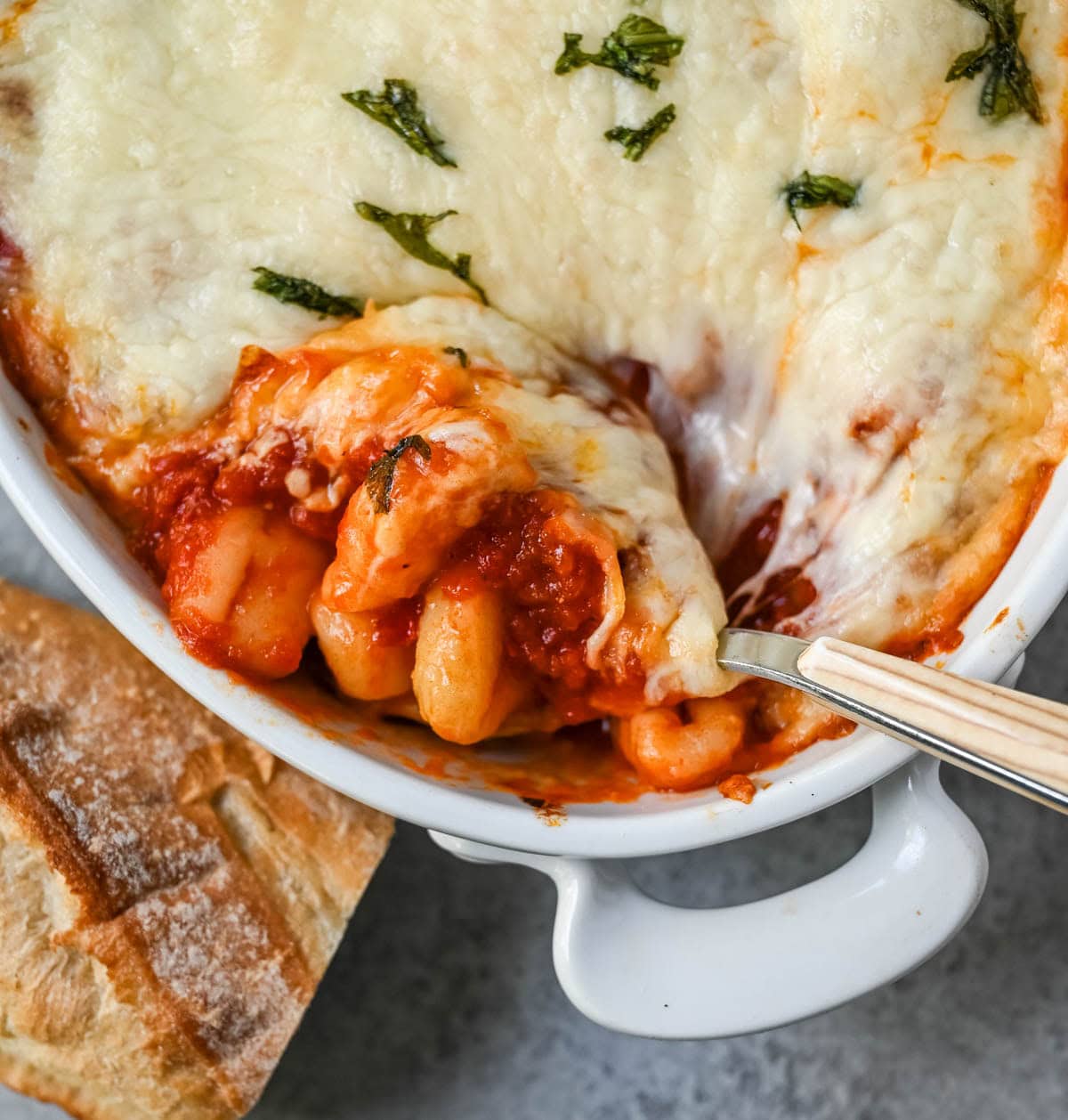 This cheesy baked gnocchi is made with pillowy gnocchi tossed in marinara sauce, layered with mozzarella and parmesan, and baked until golden and bubbly. Topped with fresh basil, this easy gnocchi bake comes together in one dish and tastes like it took hours.