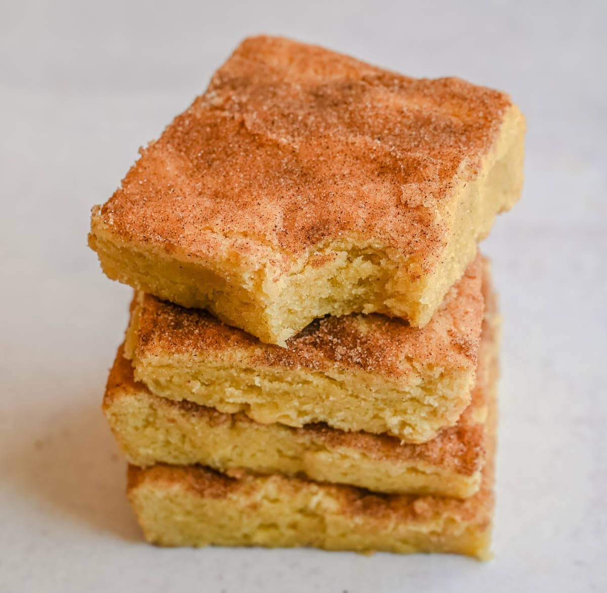 These snickerdoodle bars have all the soft, chewy, cinnamon-sugar flavor of classic snickerdoodle cookies, baked in one pan for an easier, faster version. No scooping, no rolling — just press, sprinkle, and bake for a crowd-sized batch of snickerdoodle flavor in every bite.