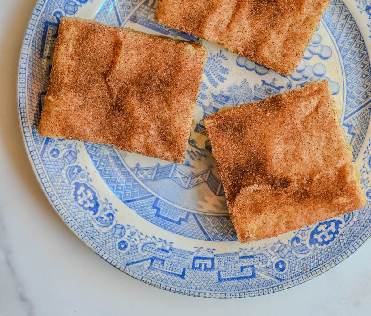 These snickerdoodle bars have all the soft, chewy, cinnamon-sugar flavor of classic snickerdoodle cookies, baked in one pan for an easier, faster version. No scooping, no rolling — just press, sprinkle, and bake for a crowd-sized batch of snickerdoodle flavor in every bite.