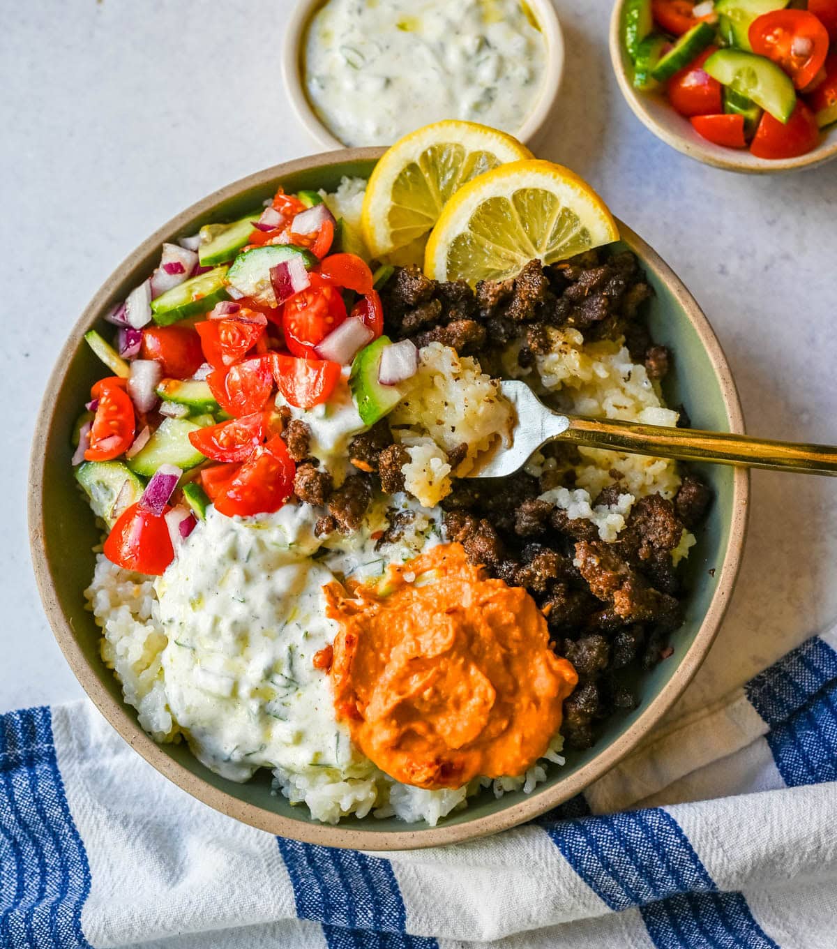 Greek Beef Bowls. Juicy seasoned ground beef, bright lemon rice, feta, cucumbers, tomatoes and tzatziki in one easy 35-minute dinner. High-protein bowls that hold up all week for lunches.