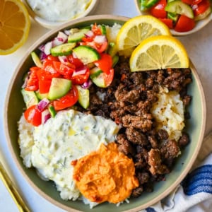Greek Beef Bowls. Juicy seasoned ground beef, bright lemon rice, feta, cucumbers, tomatoes and tzatziki in one easy 35-minute dinner. High-protein bowls that hold up all week for lunches.