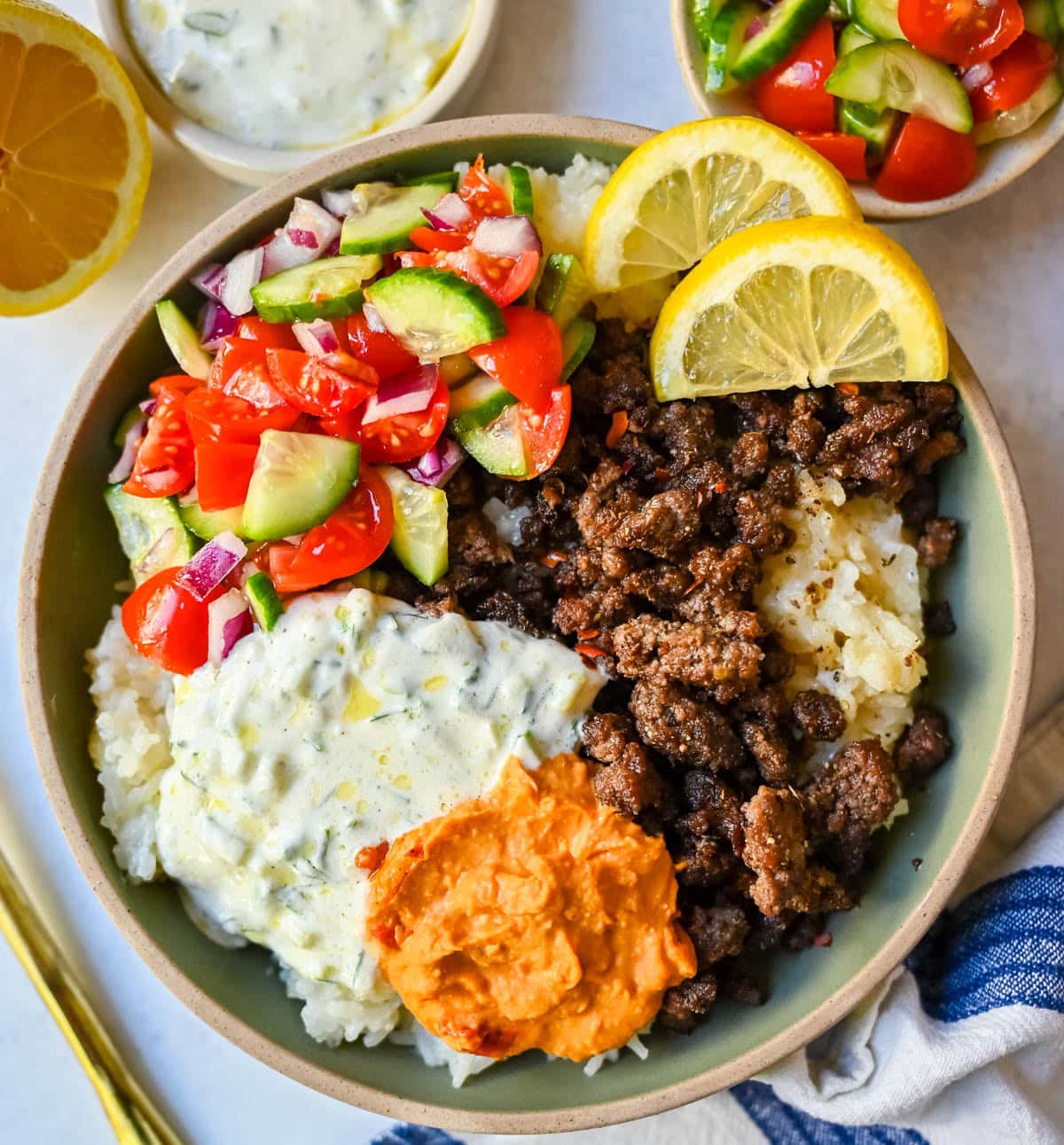 Greek Beef Bowls. Juicy seasoned ground beef, bright lemon rice, feta, cucumbers, tomatoes and tzatziki in one easy 35-minute dinner. High-protein bowls that hold up all week for lunches.