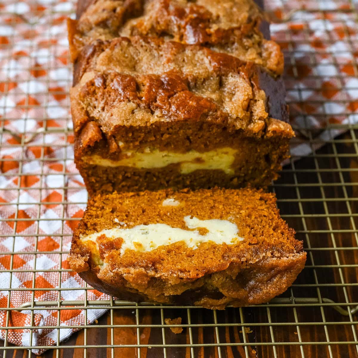 This pumpkin cream cheese bread has a thick ribbon of tangy cheesecake running through the middle, a buttery brown sugar streusel on top, and one simple trick that gives it the deepest, richest pumpkin flavor you've had in a loaf. This is the best pumpkin cream cheese bread recipe and it makes two loaves.