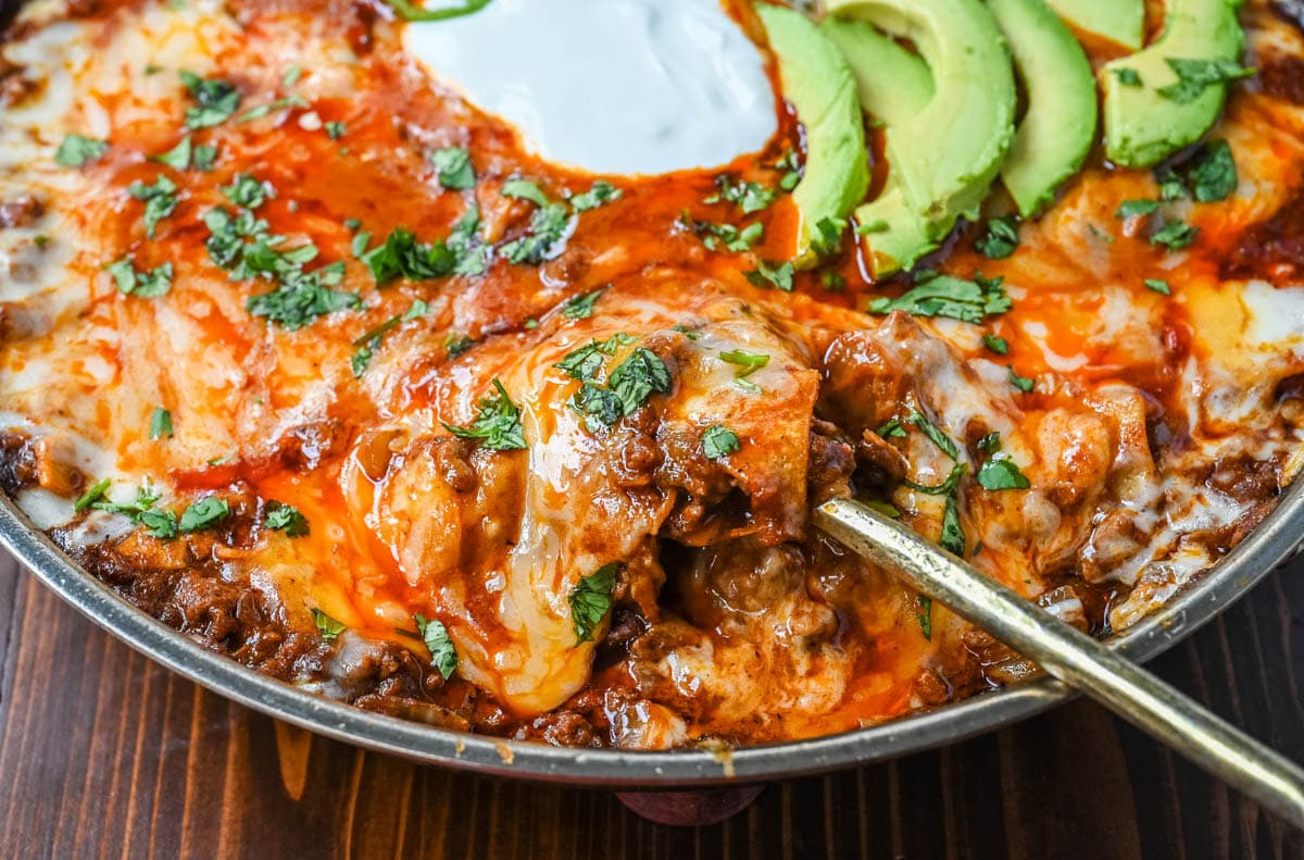 Beef enchilada skillet made with seasoned ground beef, enchilada sauce, spices, corn tortillas and cheese and toppings. An easy 30-minute dinner.