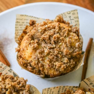 These Coffee Cake Muffins are soft, buttery, and bakery-style, with a ribbon of cinnamon pecan streusel hidden inside and a big, crumbly mound piled on top. A drizzle of sweet vanilla glaze finishes them off, and every bite tastes like your favorite sour cream coffee cake.