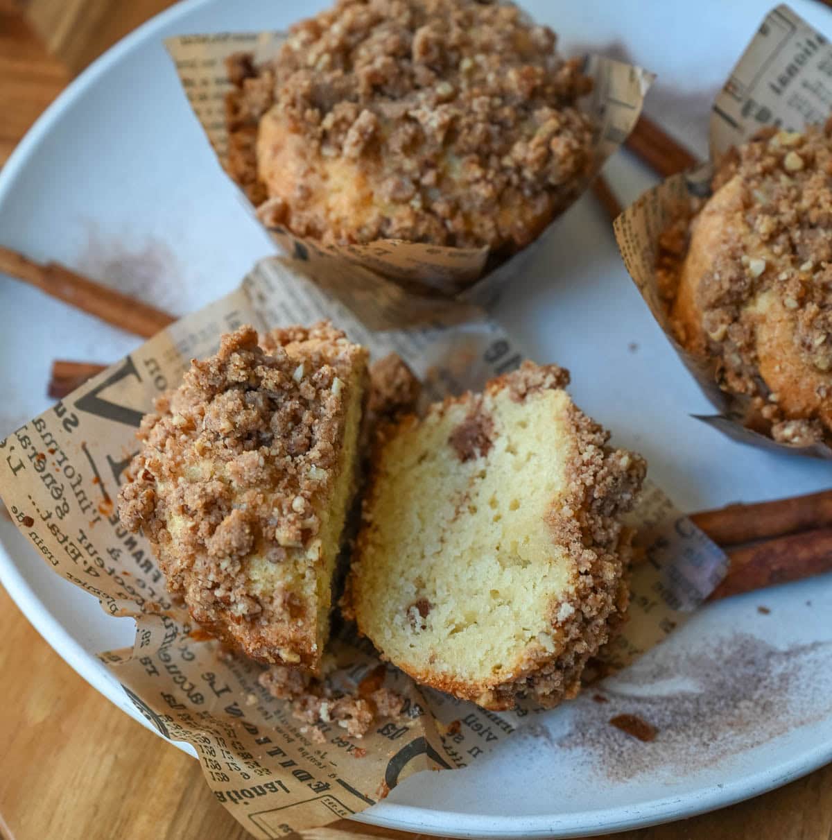 Cinnamon Coffee Cake Muffins split open with a streusel in the middle and on top.