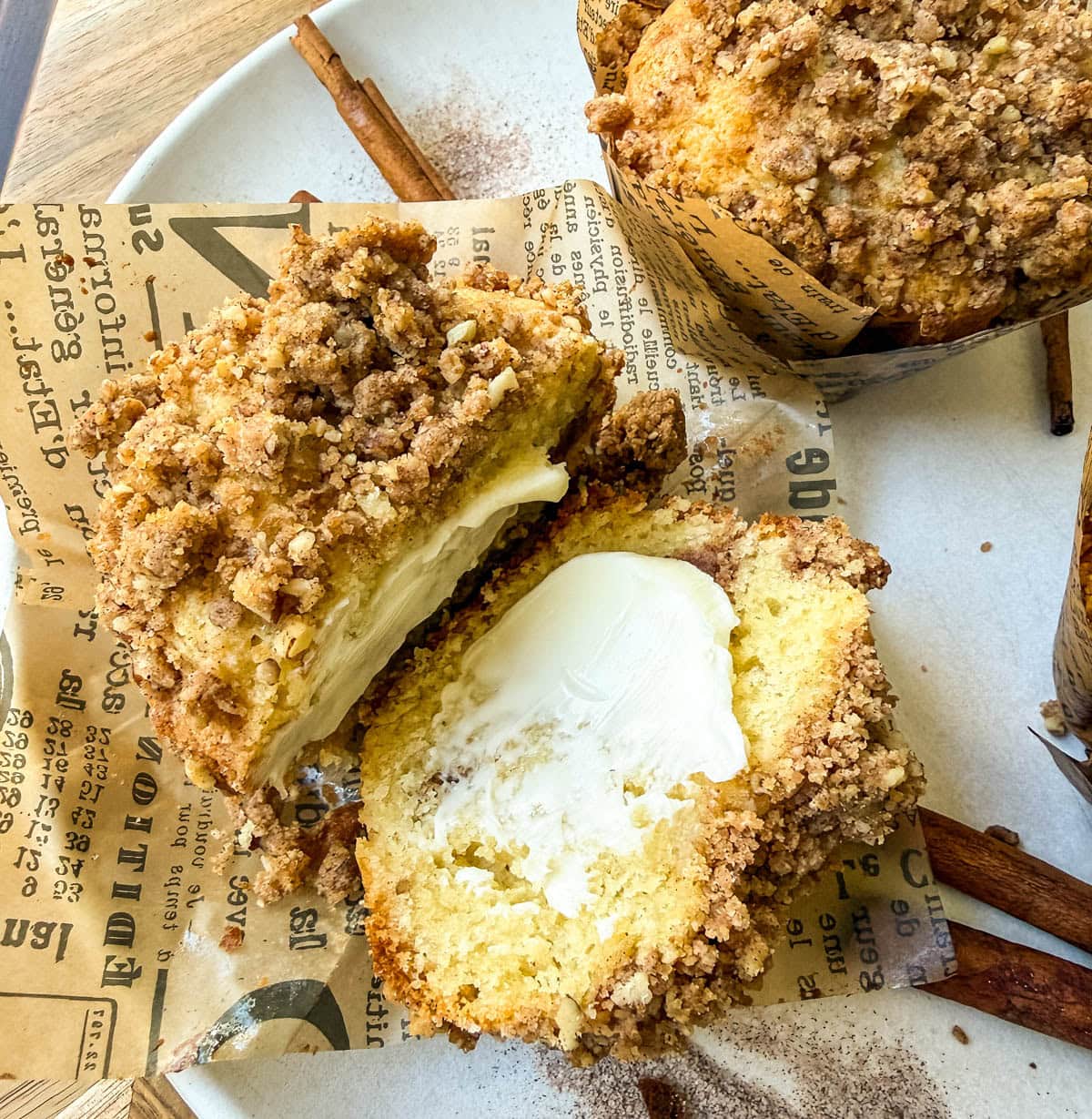 Cinnamon Sugar Coffee Cake Muffins with brown sugar streusel in the middle and on the top. Cinnamon sugar muffins cut into half with butter.