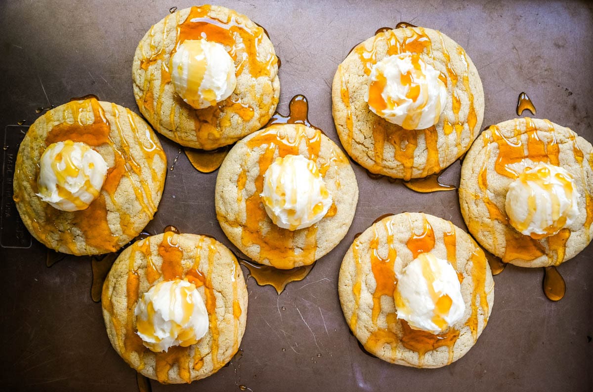 Overhead view of homemade cornbread cookies with whipped honey butter on a baking sheet.