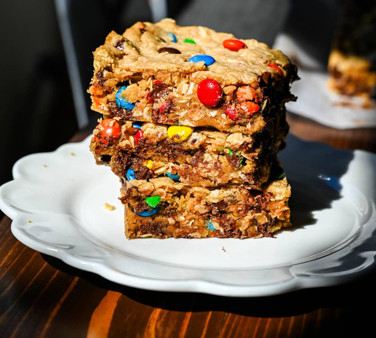These Monster Cookie Bars are thick, chewy peanut butter oatmeal bars loaded with M&M’s and chocolate chips. One bowl, one 9x13 pan, and no scooping! How to make the best monster cookie bars.
