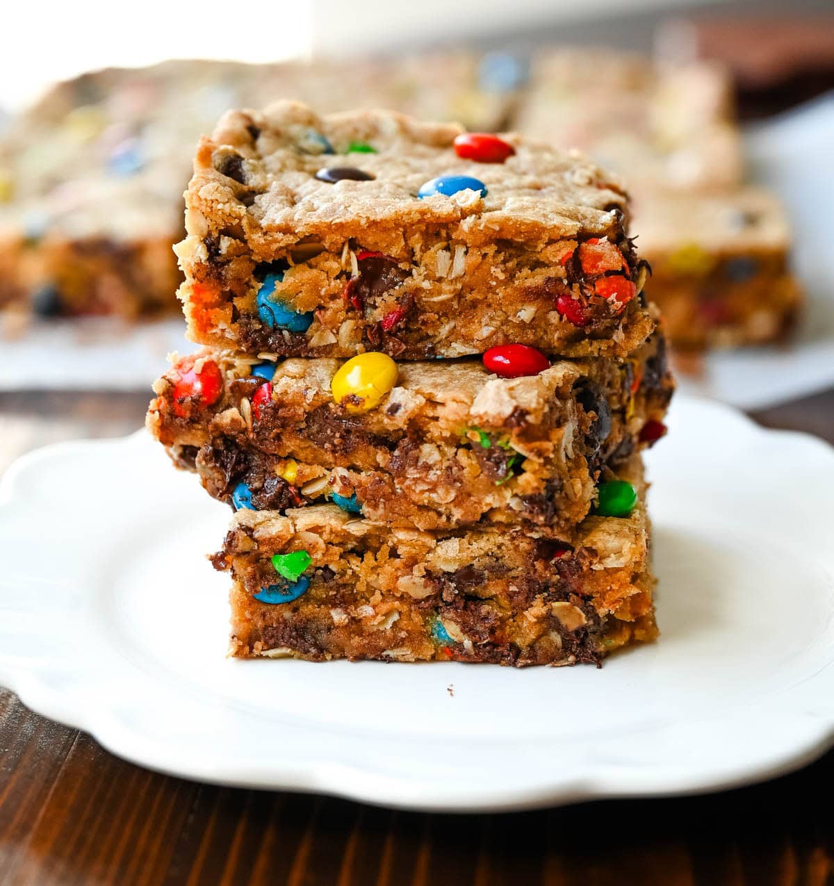 These Monster Cookie Bars take my most popular monster cookie recipe and turn it into an easy, no-scoop dessert you bake right in a 9x13 pan. They’re thick and chewy peanut butter oatmeal bars loaded with M&M’s and chocolate chips, with crisp golden edges and a soft, gooey center. If you love monster cookies but don’t want to scoop and bake batch after batch, these monster bars are for you. They are made in one bowl and feed a crowd.