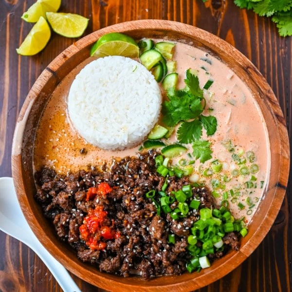 This Red Curry Beef Broth Bowl recipe is an easy weeknight dinner loaded with crispy, glazed ground beef, a creamy coconut red curry broth then topped with fresh herbs, cucumber, and sesame seeds. This easy 30-minute recipe is packed with flavor and comes together faster than takeout.