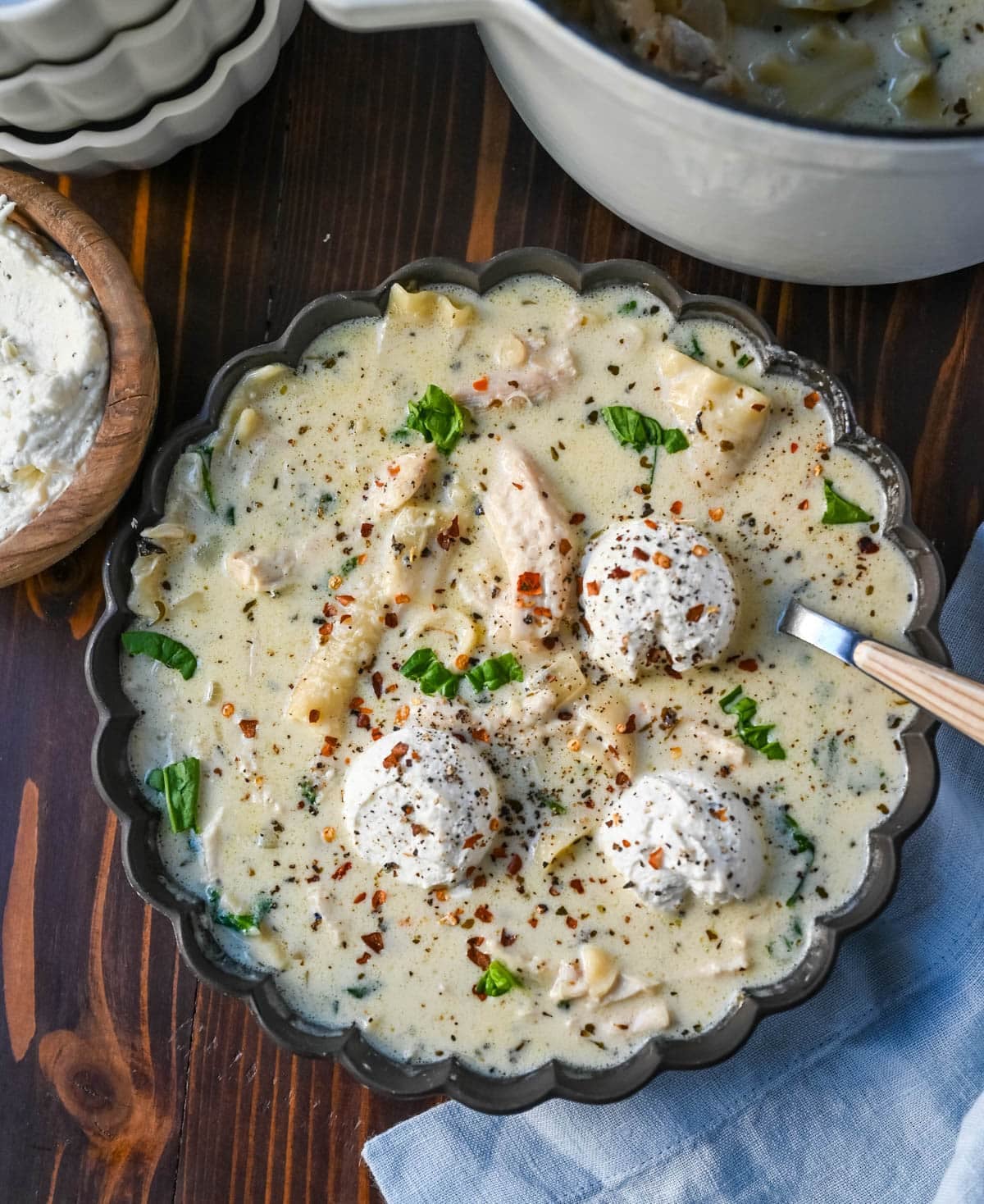 This White Chicken Lasagna Soup is everything you love about a creamy, cheesy chicken lasagna, without all the layering! Lasagna noodles, tender shredded chicken, and spinach all simmer together in one pot in a garlicky parmesan cream broth. Then you top each bowl with a dollop of herbed ricotta that melts right in.